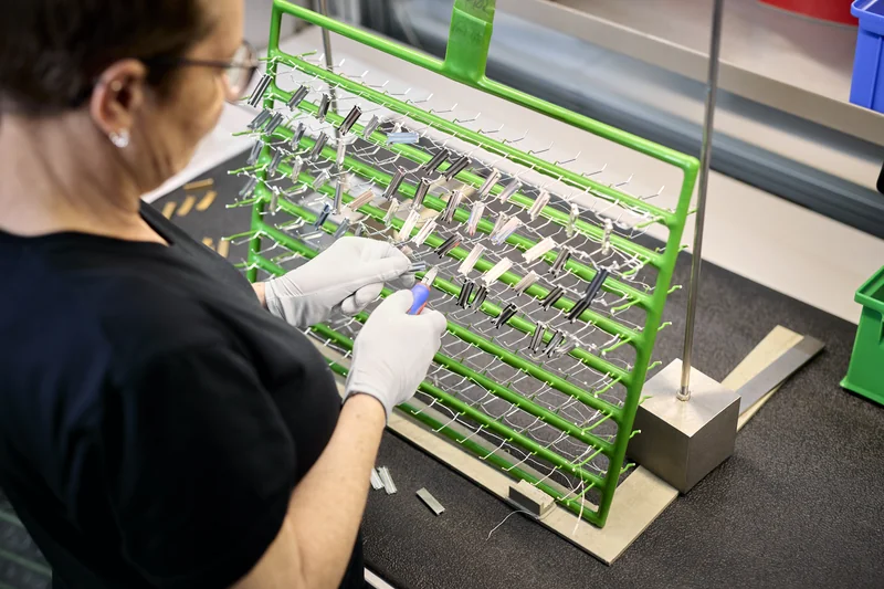 Mitarbeiterin der C. Jentner GmbH in Pforzheim bestückt Gestellrahmen mit Bauteilen