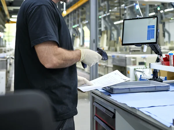 Mitarbeiter der C. Jentner GmbH scannt Auftragspapiere zur Rückverfolgbarkeit in der Produktion