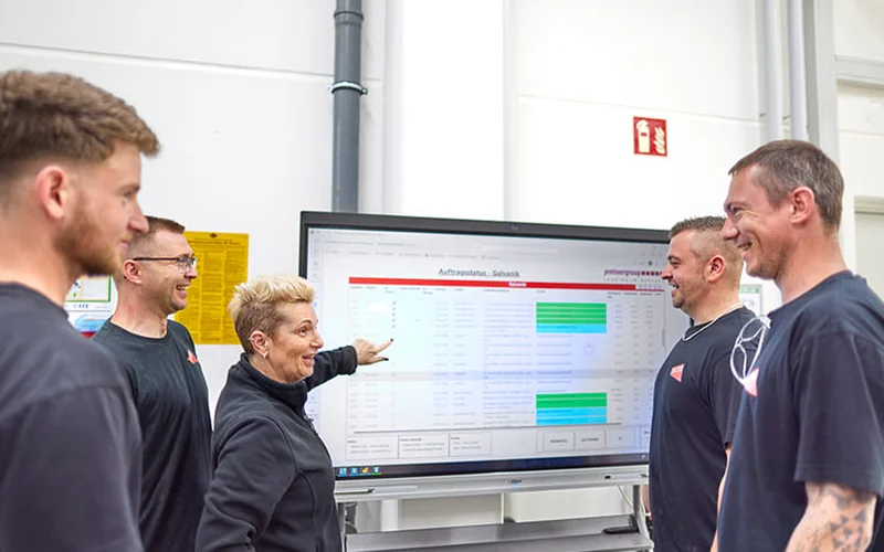 Team der C. Jentner GmbH vor dem Monitoring-Board von Jentner AI in der Produktion